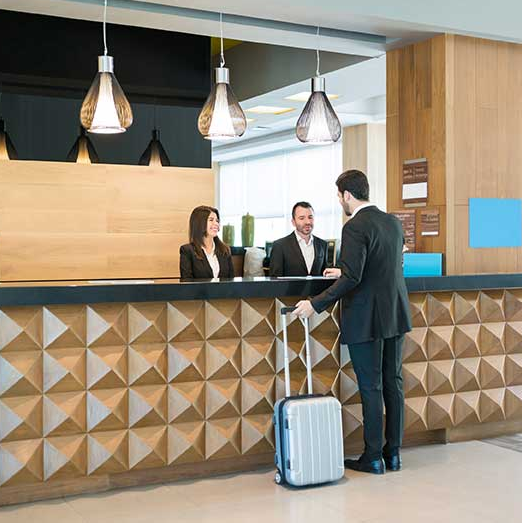 Réceptionniste d'hôtel accueillant des clients - Recrutement hôtellerie Pons Charente-Maritime