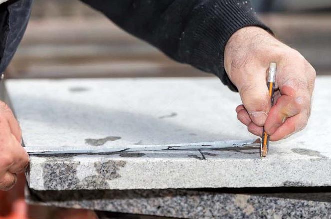 Marbrier funéraire posant un monument funéraire