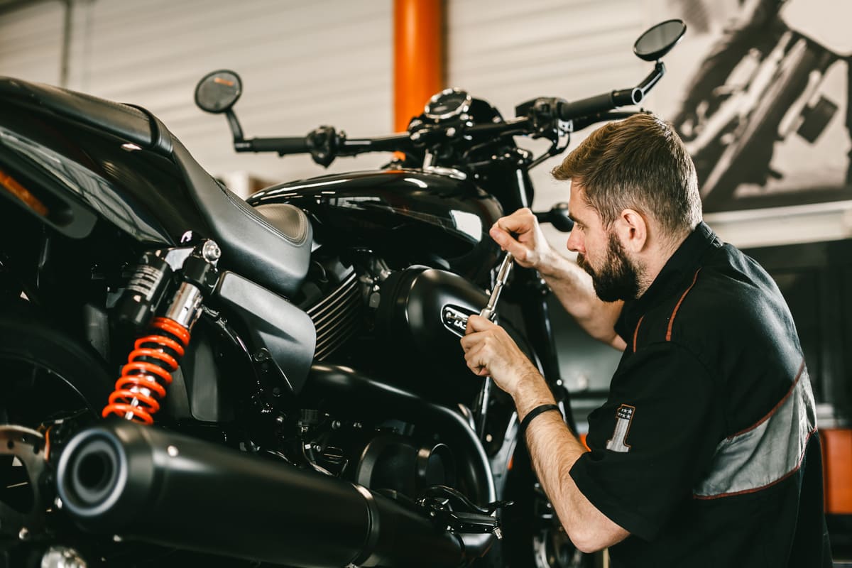 Mécanicien moto effectuant une réparation sur une moto dans un atelier